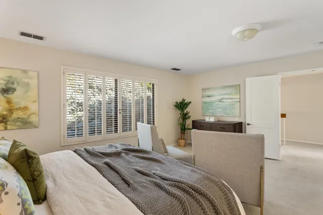 a bedroom with a large bed and a large window