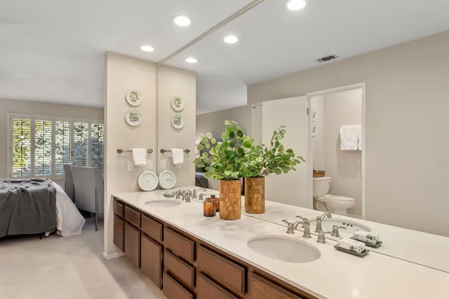 a bathroom with double vanity sinks a large mirror and a shower