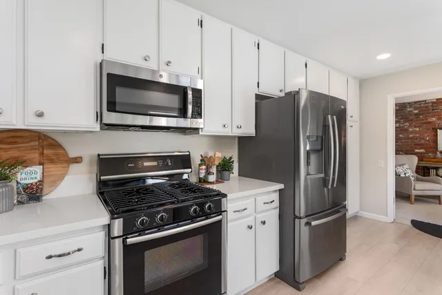 a kitchen with stainless steel appliances a refrigerator stove and microwave