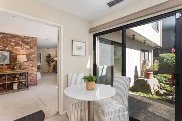 a dining room with furniture and a floor to ceiling window