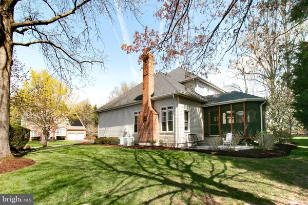 a view of a white house with a big yard and large tree