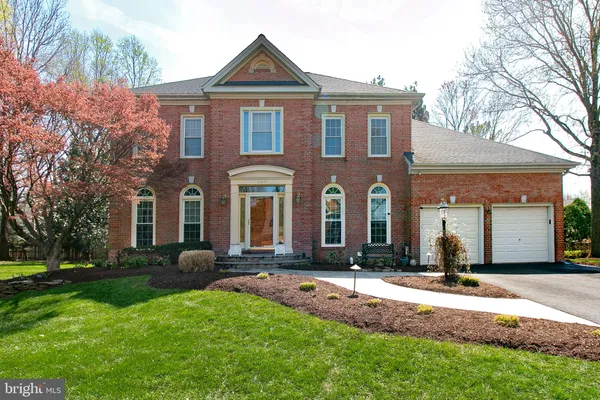 a front view of a house with yard and green space