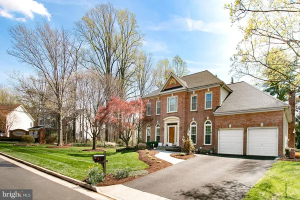 a front view of a house with a yard and trees