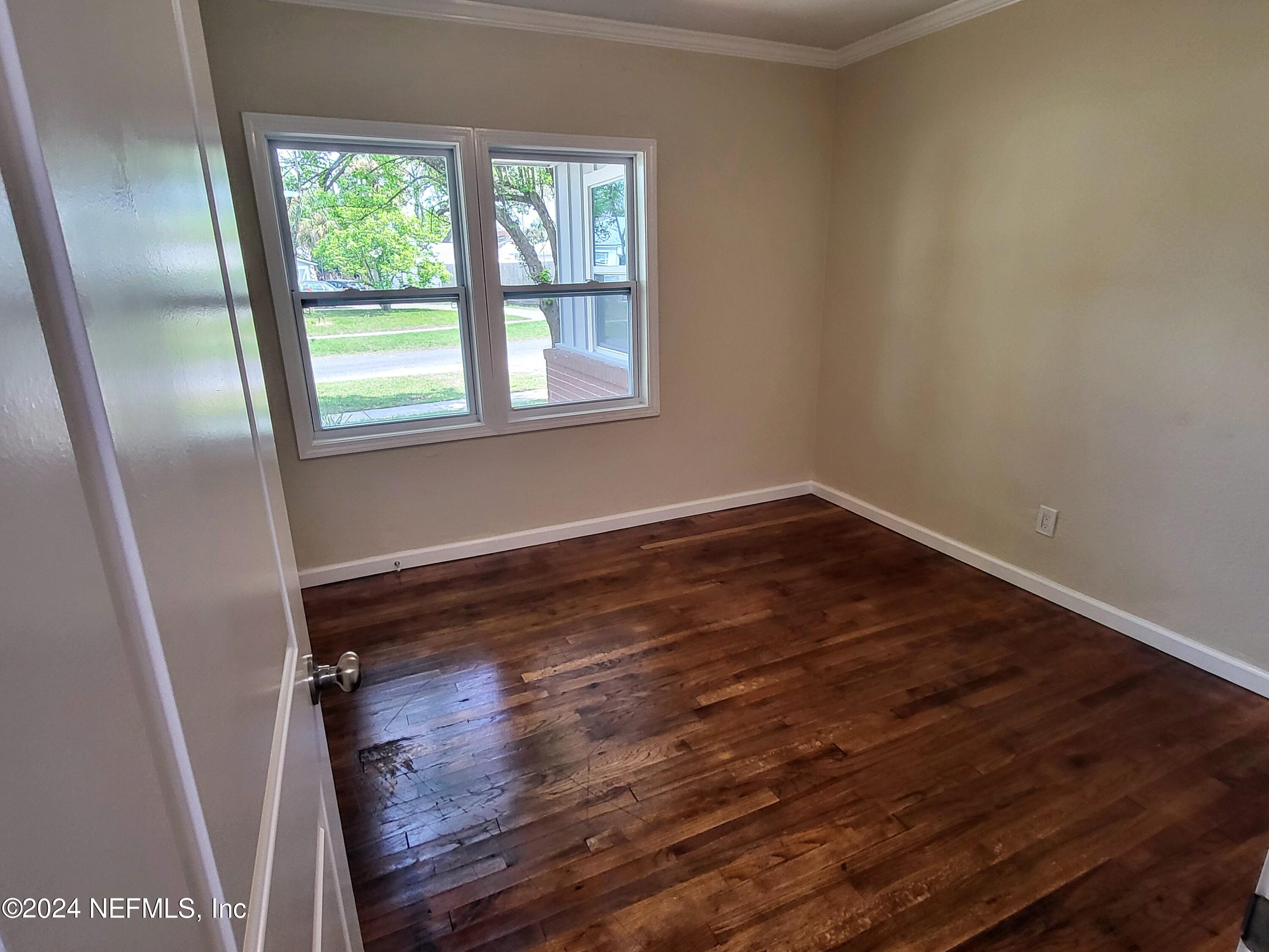 4718 Dundee Road Jacksonville, FL 32210 - Photo 13 of 37 a view of a room with wooden floor and window