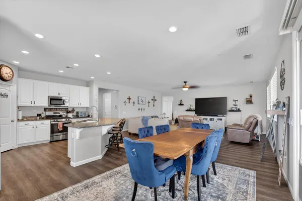 a living room with stainless steel appliances kitchen island furniture and a flat screen tv