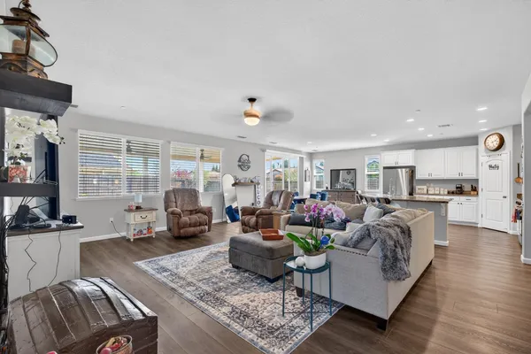 a living room with furniture kitchen view and a large window