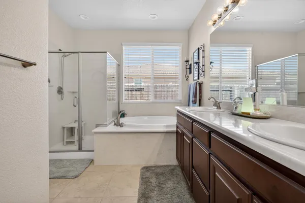 a bathroom with a granite countertop sink a large mirror and a bathtub