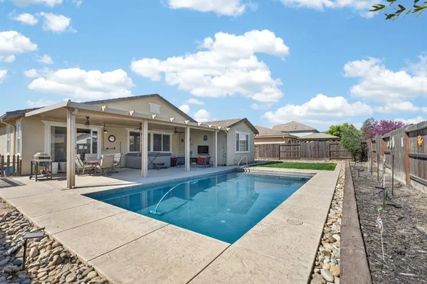 a view of a house with swimming pool and sitting area
