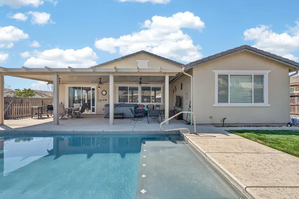 a view of house with yard and sitting area