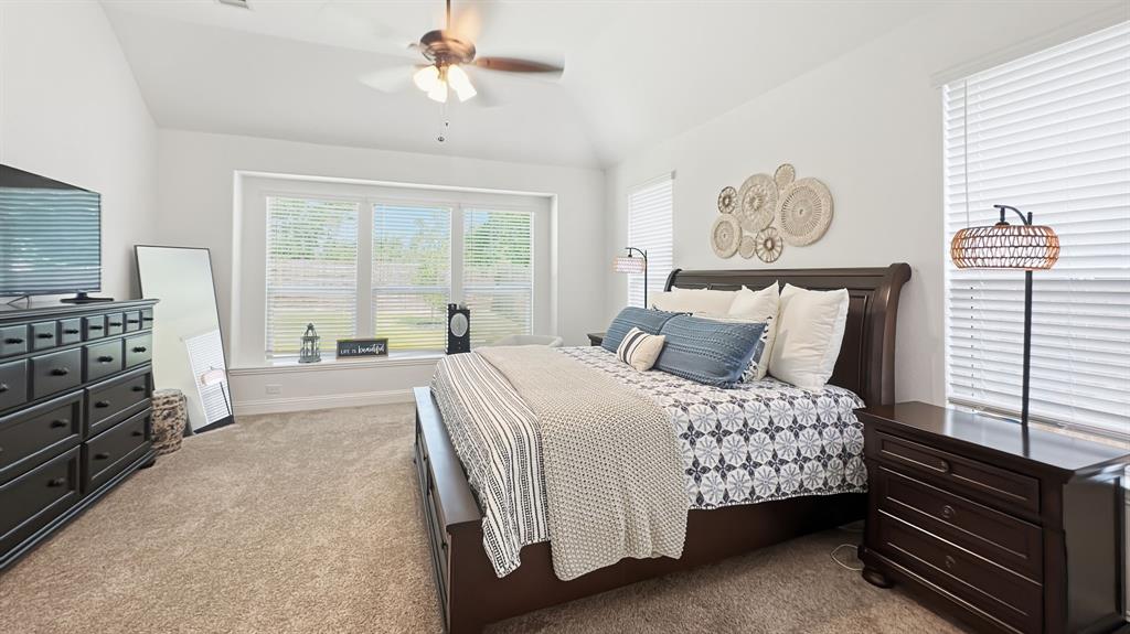 5216 Troupe Road McKinney, TX 75071 - Photo 22 of 40 Vaulted ceiling room featuring a large window with white horizontal blinds, light beige carpet, and a ceiling fan with integrated lighting
