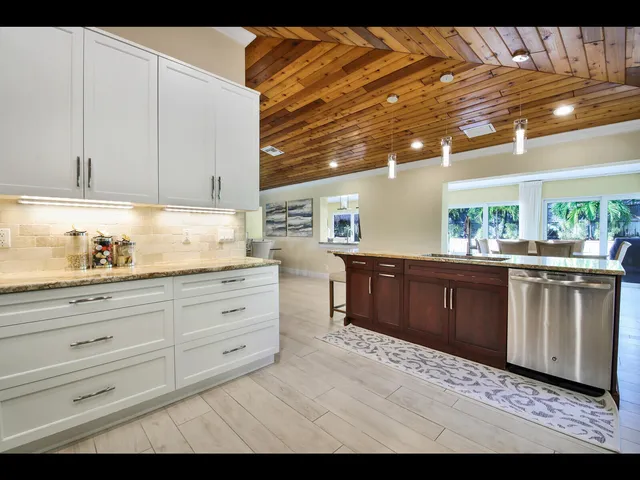 a kitchen with granite countertop a sink and cabinets