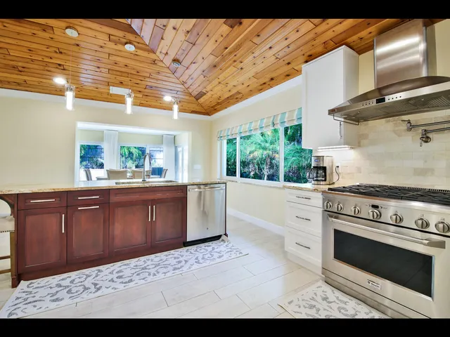 a kitchen with stainless steel appliances granite countertop a stove a sink and a refrigerator