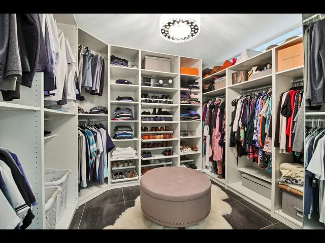 a view of walk in closet with clothes and shoes