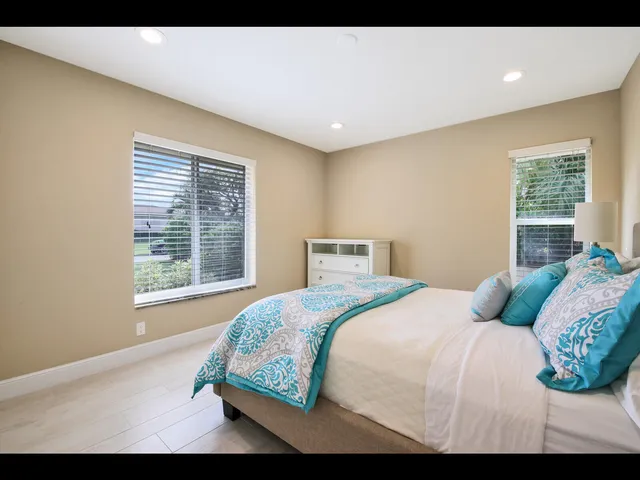 a bedroom with a bed and a large window