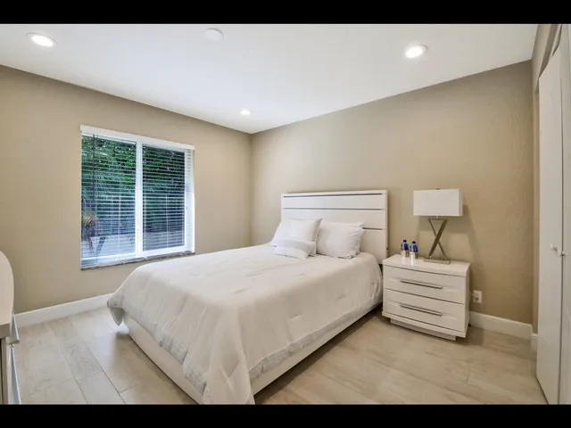 a bedroom with a bed and a large window