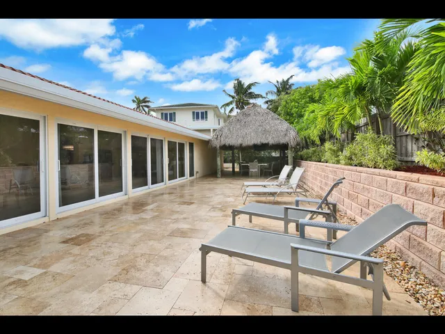 a view of a patio with couches table and chairs and potted plants