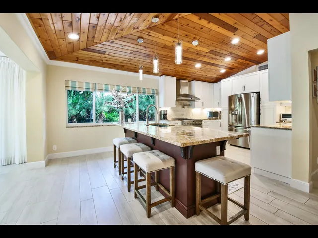 a kitchen with granite countertop a table chairs stove and refrigerator