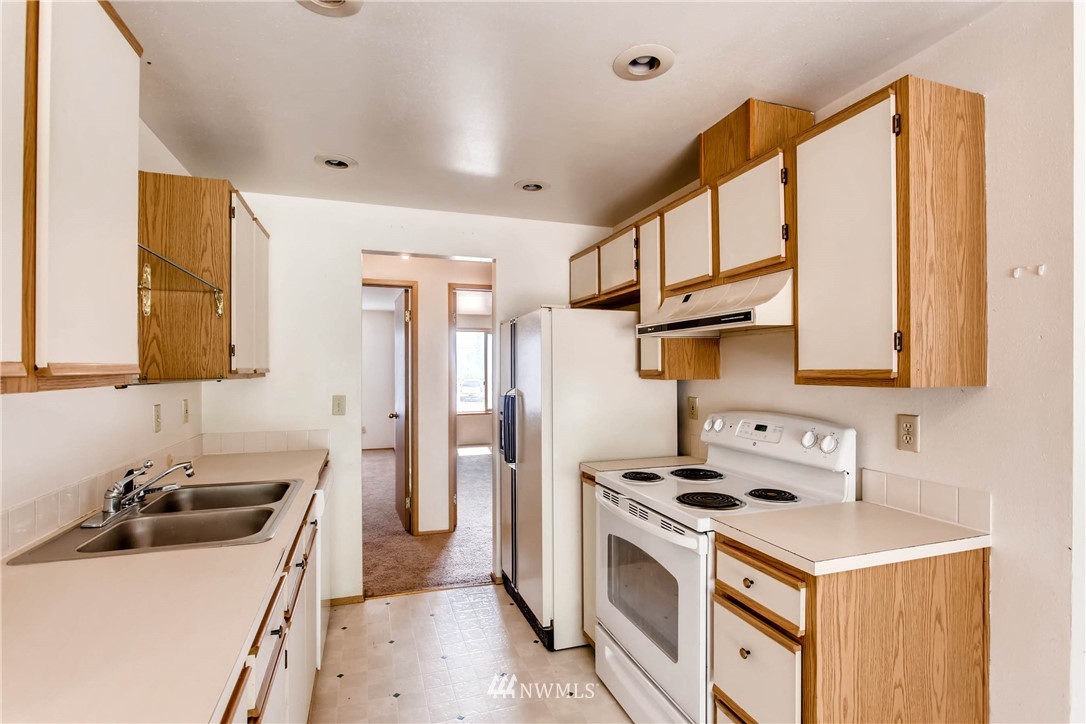 109 West Winesap Road Bothell, WA 98012 - Photo 6 of 22 a kitchen with a stove a sink and a refrigerator