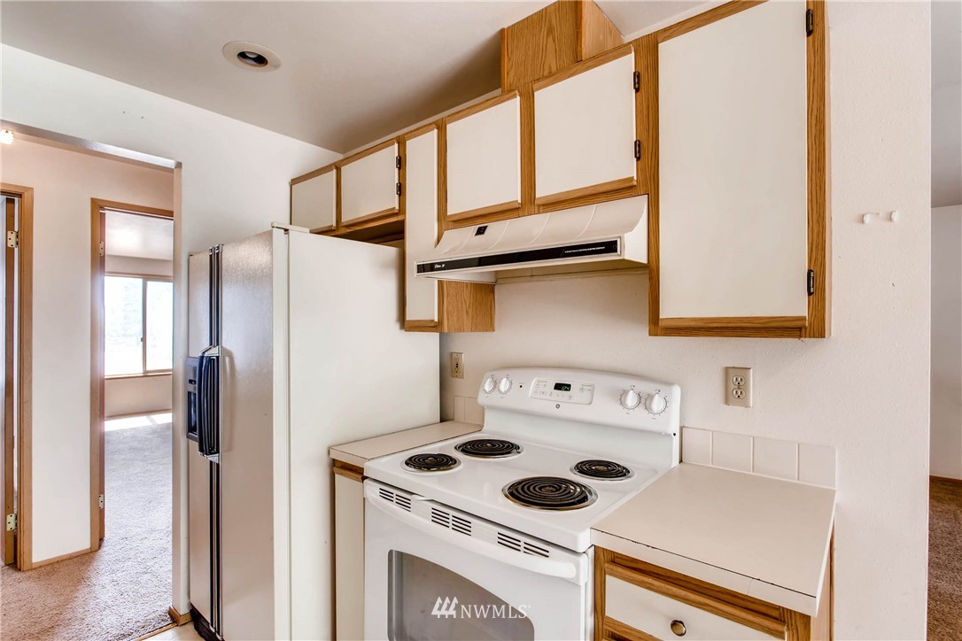 109 West Winesap Road Bothell, WA 98012 - Photo 9 of 22 a kitchen with a refrigerator a stove and a window