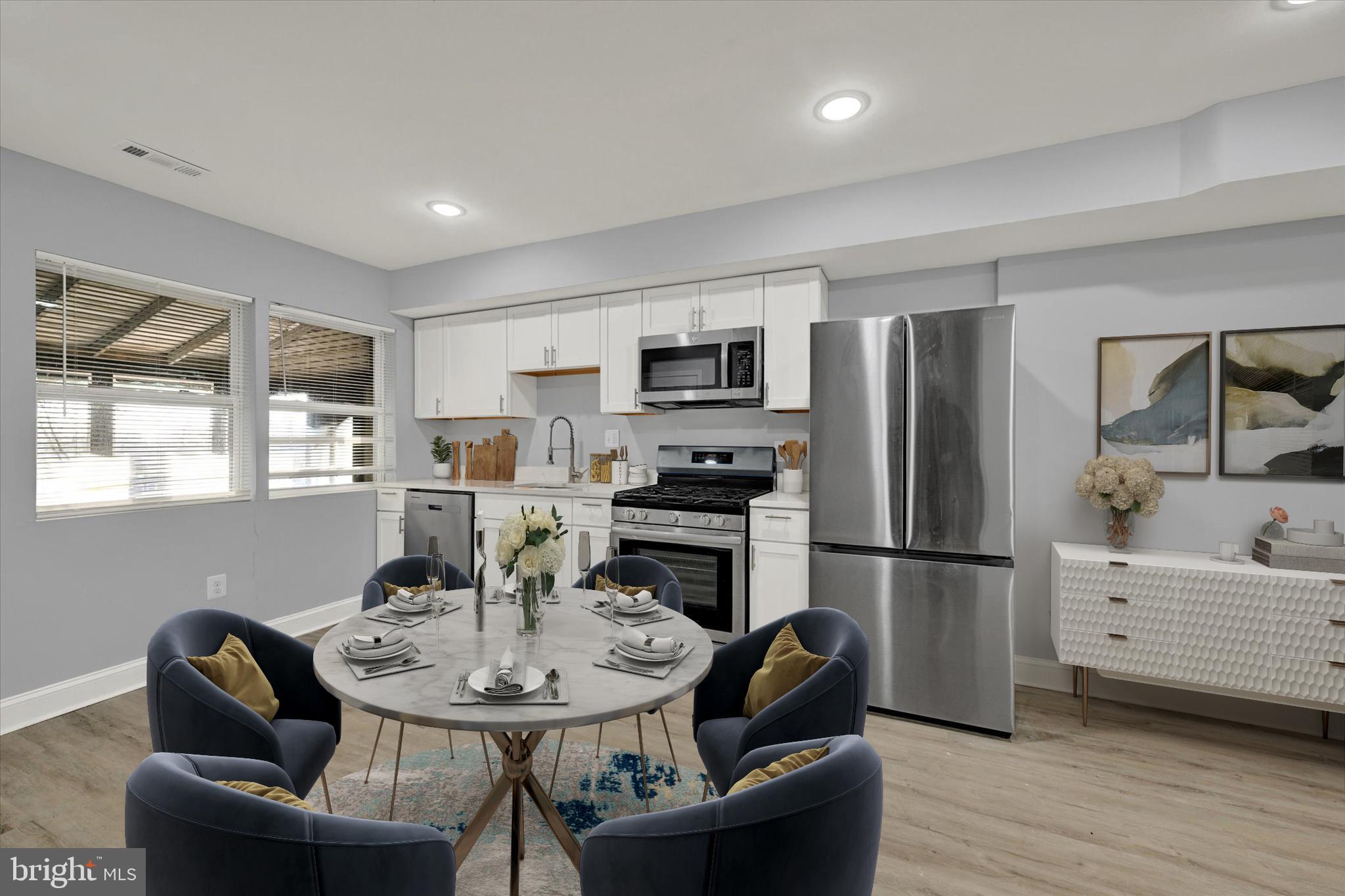 3105 Frisby Street Baltimore, MD 21218 - Photo 7 of 22 a kitchen with stainless steel appliances kitchen island granite countertop a refrigerator a stove a microwave oven a dining table and chairs
