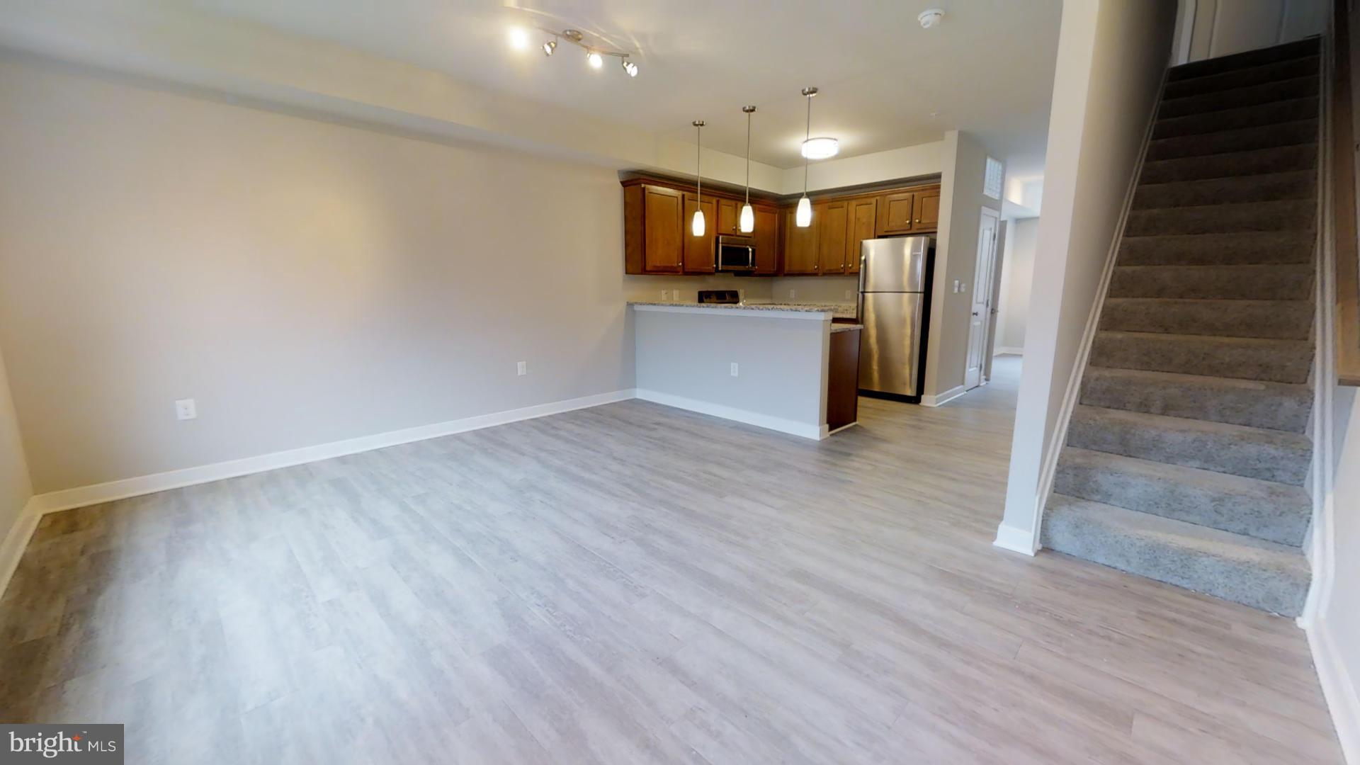 1262 Talbert Street Southeast, Unit A Washington, DC 20020 - Photo 2 of 20 a view of a hallway with wooden floor and a kitchen