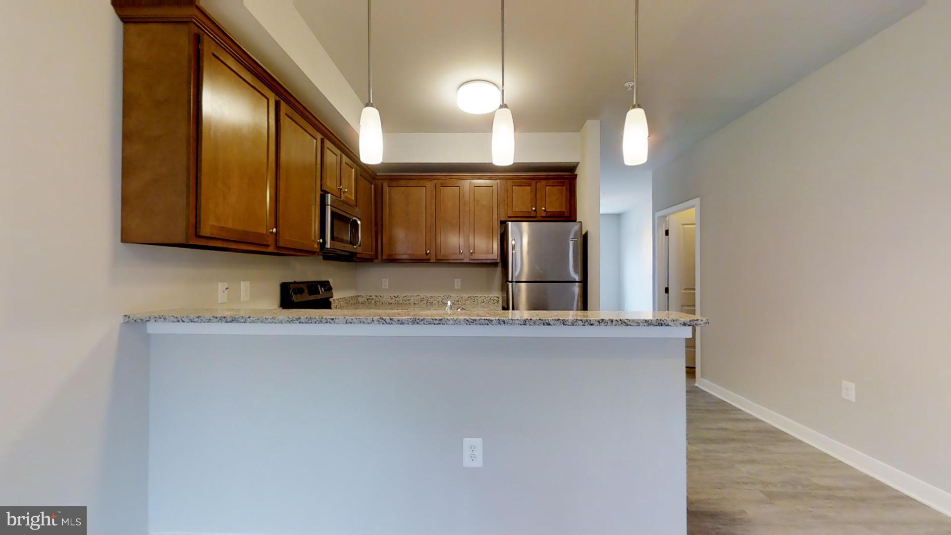 1262 Talbert Street Southeast, Unit A Washington, DC 20020 - Photo 3 of 20 a kitchen with stainless steel appliances granite countertop a sink a stove and a refrigerator