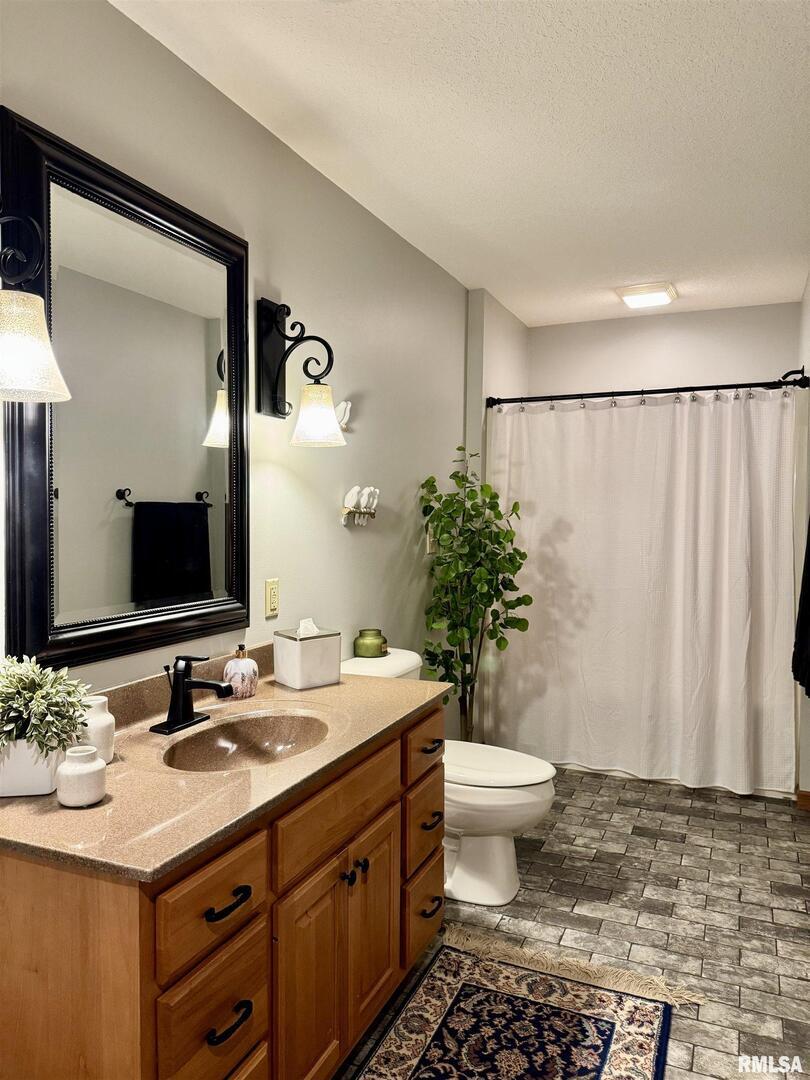 102 5th Street, Unit 6 Fulton, IL 61252 - Photo 37 of 42 a bathroom with a sink a toilet a mirror and shower curtain