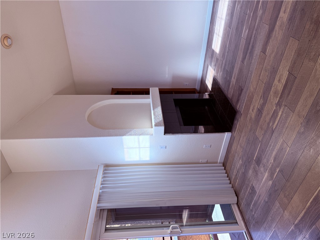 9325 West Desert Inn Road, Unit 260 Las Vegas, NV 89117 - Photo 6 of 42 Hardwood-style flooring and a tiled fireplace elevate this inviting living space.