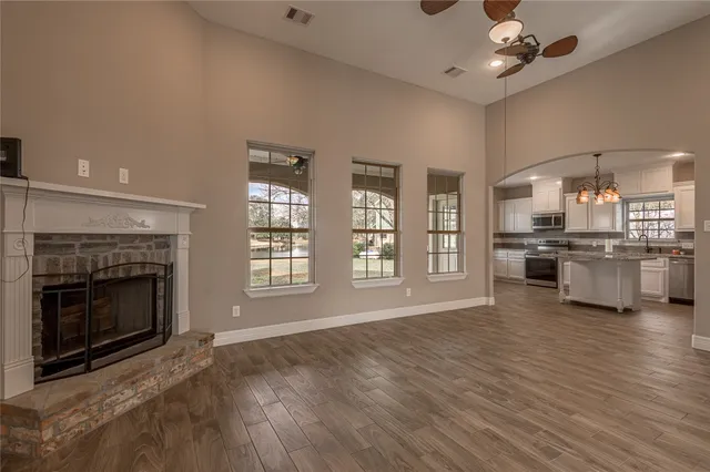 a view of an empty room with a kitchen and a fireplace