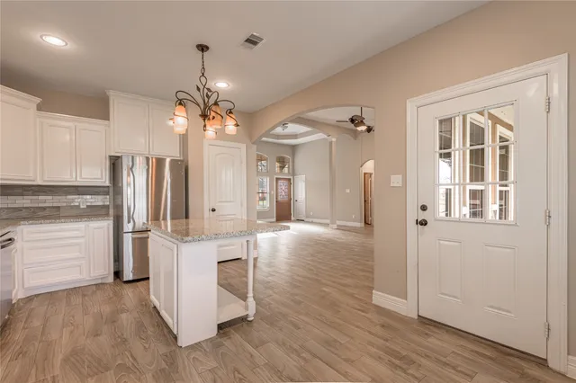 a open kitchen with white cabinets and stainless steel appliances