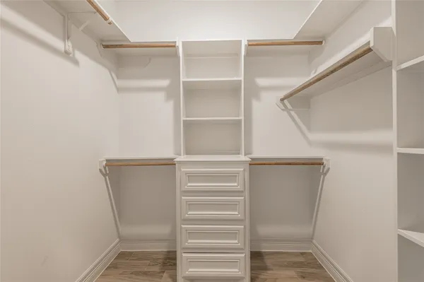 a view of walk in closet with empty racks