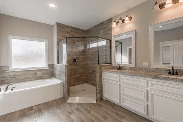 a bathroom with a granite countertop sink mirror bathtub and double