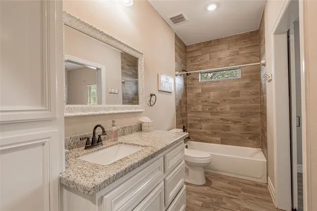 a bathroom with a granite countertop sink toilet and shower