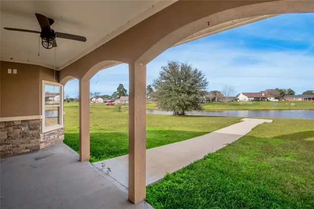 a view of a house with a yard and a large tree
