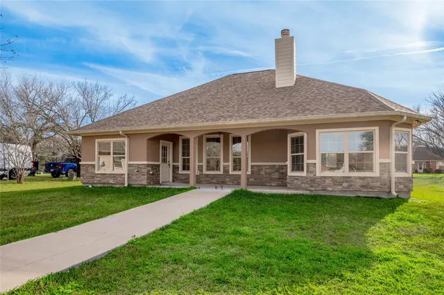 a front view of house with a garden and patio