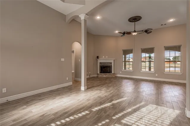 a view of an empty room with window and wooden floor