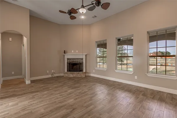 an empty room with windows and fireplace
