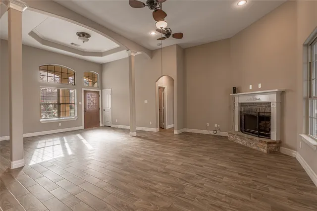 a view of empty room with wooden floor and fireplace