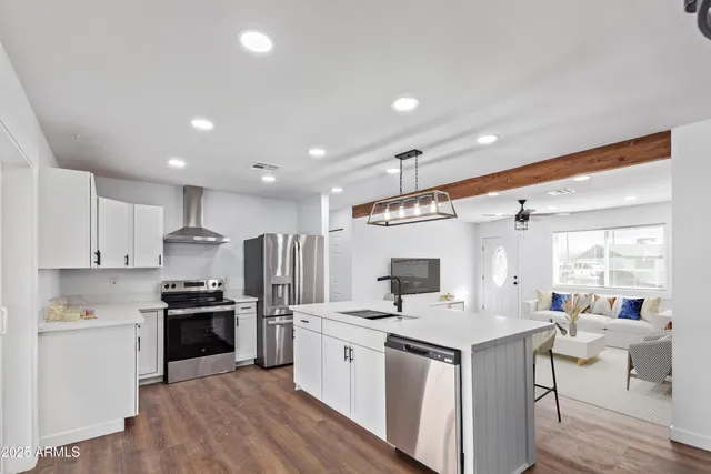a kitchen with white cabinets and stainless steel appliances