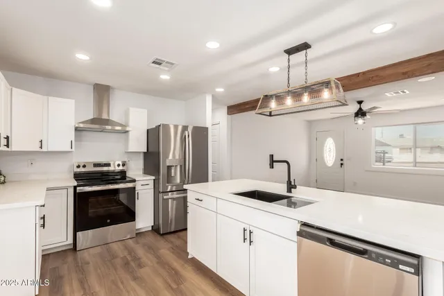 a kitchen with kitchen island a sink stainless steel appliances and cabinets