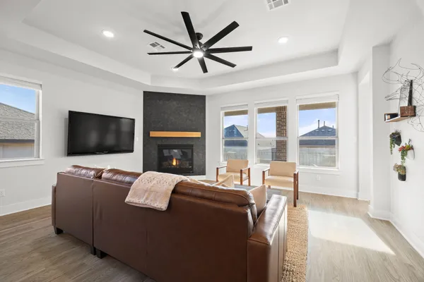 a living room with furniture a flat screen tv and a fireplace