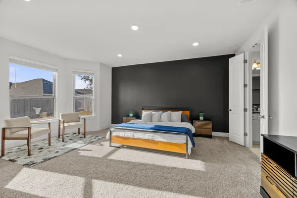 a spacious bedroom with a bed and a table in it