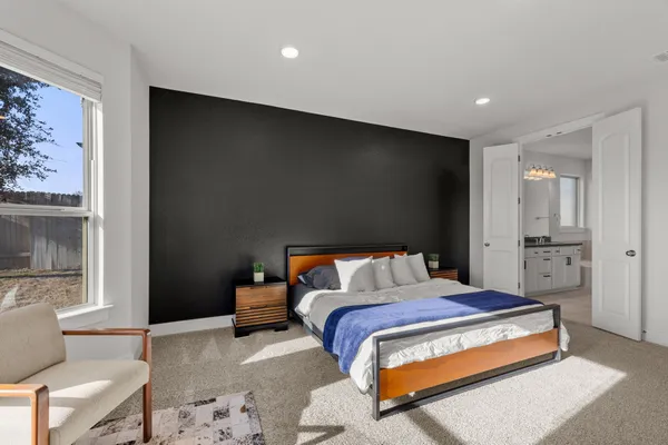 a bedroom with a bed and glass door