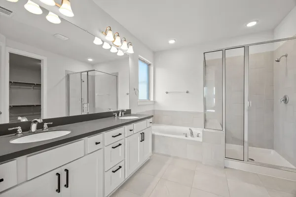 a bathroom with a double vanity sink and mirror with shower