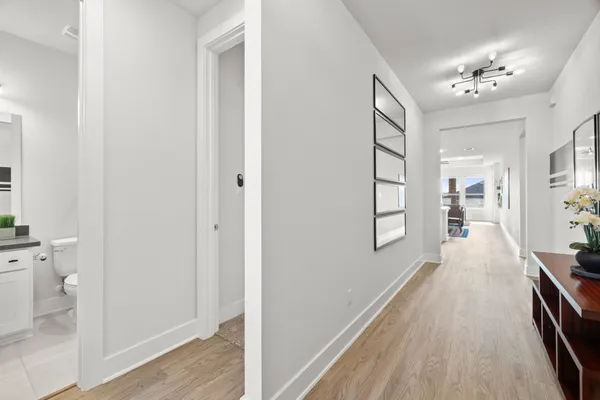 a view of a hallway with wooden floor and a living room