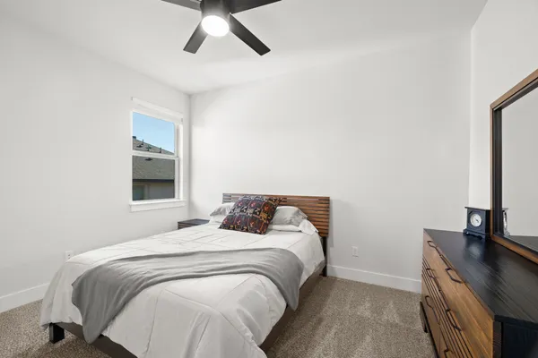 a bedroom with a bed and a flat tv screen on a dresser