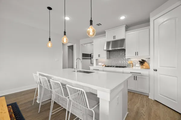 a kitchen that has a lot of cabinets in it with stainless steel appliances