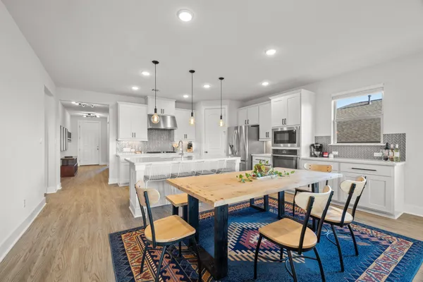 a large kitchen with dining table and chairs