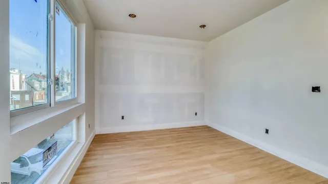 a view of empty room with wooden floor