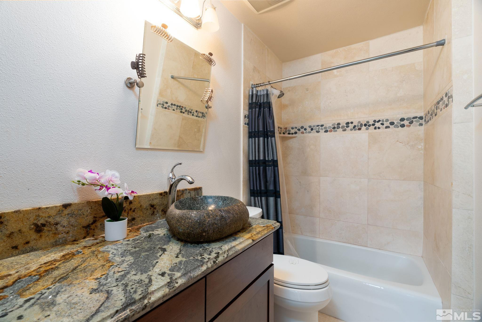 15350 Yankee Blade Road Reno, NV 89521 - Photo 15 of 27 a bathroom with a granite countertop sink a toilet and shower